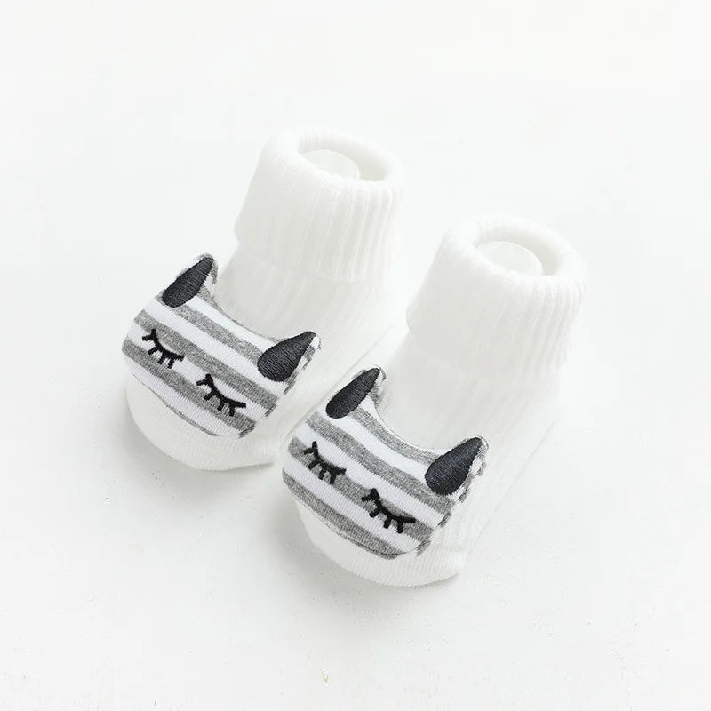 A pair of white cotton socks with gray cartoon animal prints for babies and toddlers.