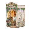 A miniature wooden book nook kit depicting Monet's studio with greenery and antique elements.