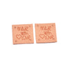 Two pink embossed leather labels with the text Made with Love stamped on them