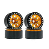 A pair of black metal beadlock wheels with an orange center and removable hex hub for an RC crawler.