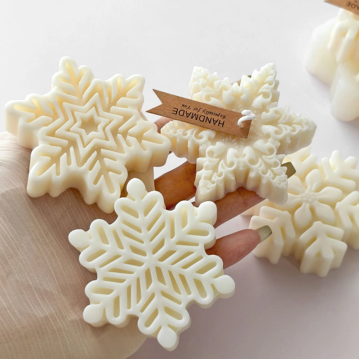 White snowflake silicone mold for candle soap and wax melts displayed on a wooden surface.