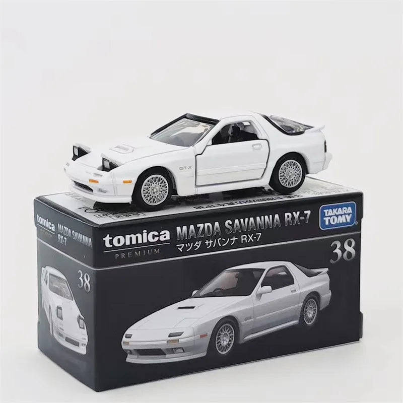 A white Mazda Savanna RX-7 die-cast model by Tomica in a box.