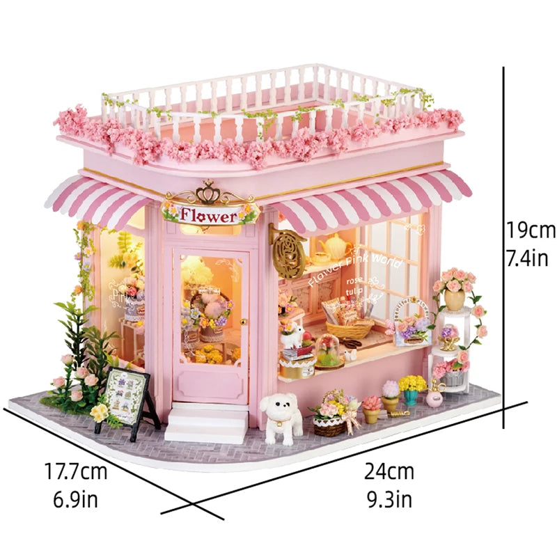 Pink miniature dollhouse kit featuring a storefront with flowers and warm lighting.