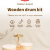 A wooden drum kit set with various components displayed on a light fabric background.