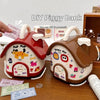 A DIY piggy bank shaped like a house with a roof and door, featuring various coins and a lock and key.
