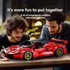 A red MOC hypercar building blocks set is displayed on a wooden table with two men in the background.