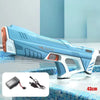 A blue and white electric automatic water gun is shown resting on a tiled surface, with its battery and charging cable displa