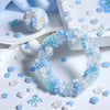 A circular wreath made of blue and white resin flowers is displayed on a white surface with scattered small floral pieces.