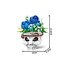 A set of white building blocks shaped like a skull, decorated with blue and white flowers and greenery.