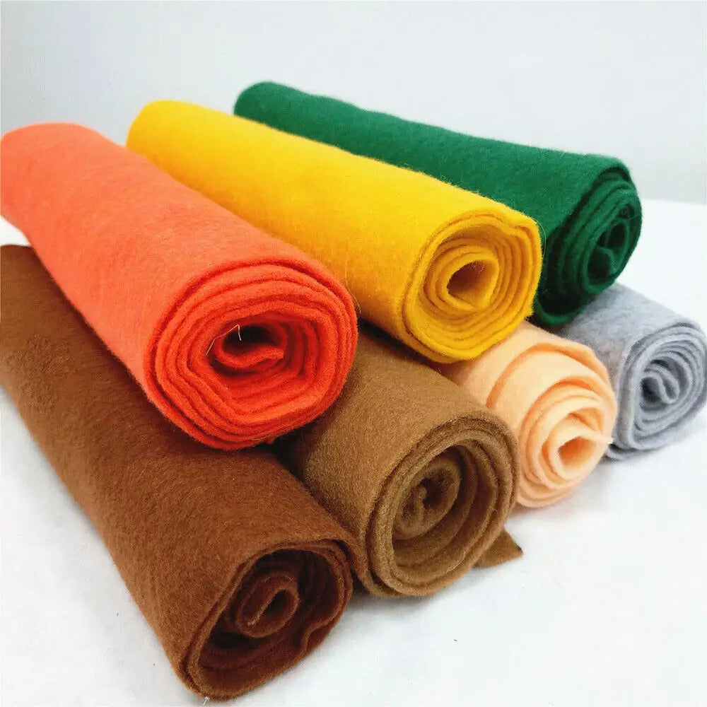 A collection of rolled felt fabric sheets in orange, yellow, green, and brown colors.