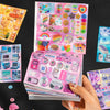 A hand holds a stack of Kawaii Cyber Illusion & Vintage Starlight Die-Cut Sticker Pack featuring colorful, sparkly stickers.