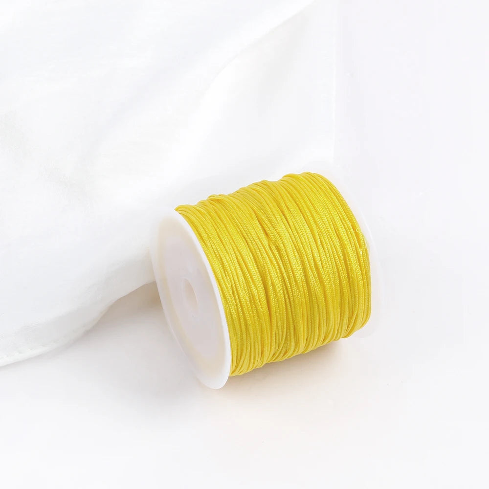 A roll of bright yellow 0.8mm cotton nylon macrame cord for jewelry making and crafts.