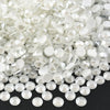 A pile of clear and white sparkling crystal flatback rhinestones for nail art and crafts.