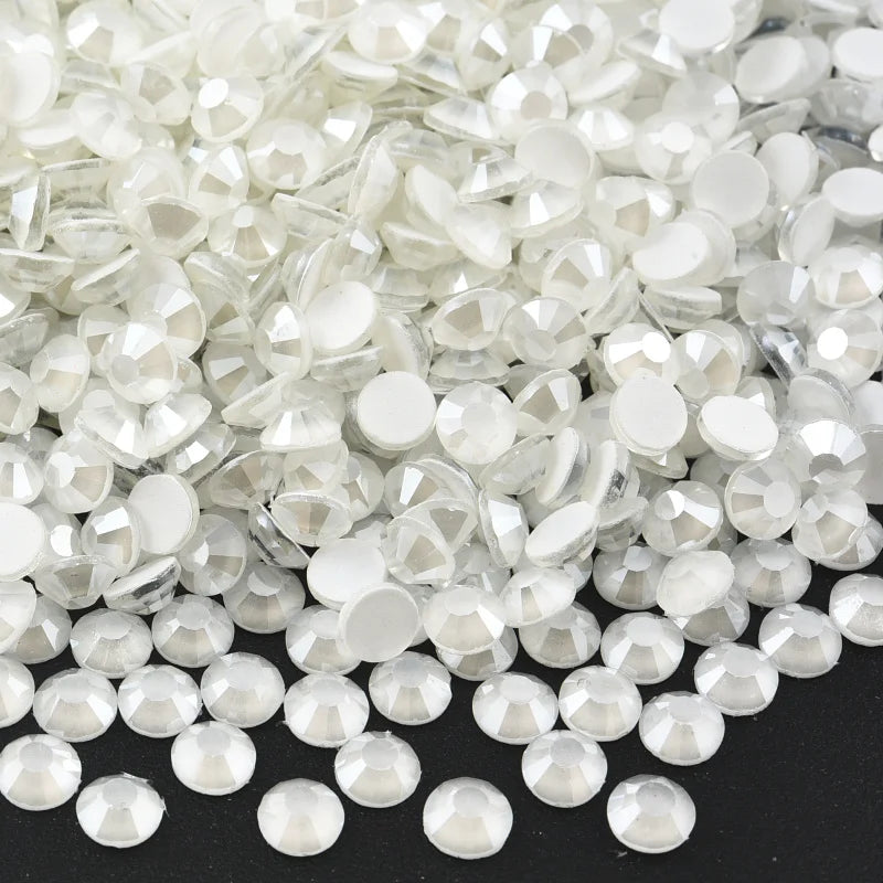 A pile of clear and white sparkling crystal flatback rhinestones for nail art and crafts.