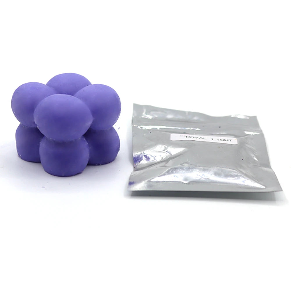 A pile of purple candle dye chips for soy wax, beeswax, and paraffin.