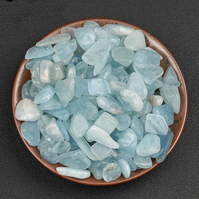 A bowl filled with light blue to pale blue translucent aquamarine chips for DIY decor or aquariums.