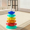 A colorful stacking tower of rings in rainbow colors on a light carpet.