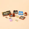 A collection of wooden building blocks shaped like various foods and items including honey, cookies, and cheese.