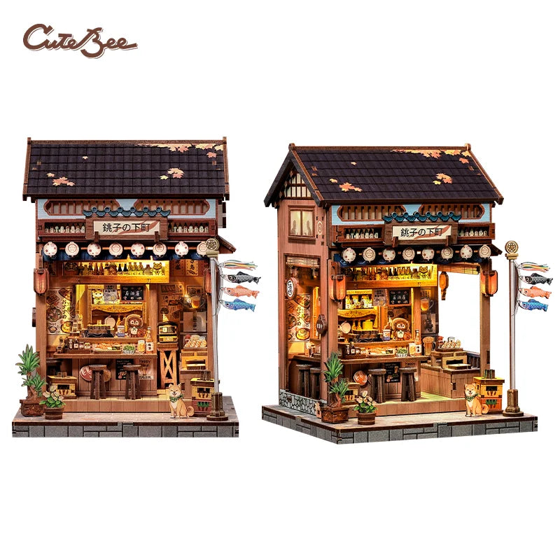 A detailed 3D wooden book nook kit featuring a traditional shop facade with LED lighting and miniature figures.