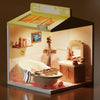 A miniature DIY dollhouse kit featuring furniture and room themes displayed within an open box.