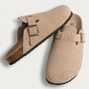 Tan suede cork mules with leather straps and arch support shown from the side.