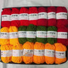 A pack of red, green, and orange acrylic yarn skeins for knitting and crochet crafts.
