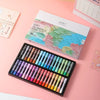 A set of 36 soft oil pastels in various colors is displayed on a pink surface next to its packaging.
