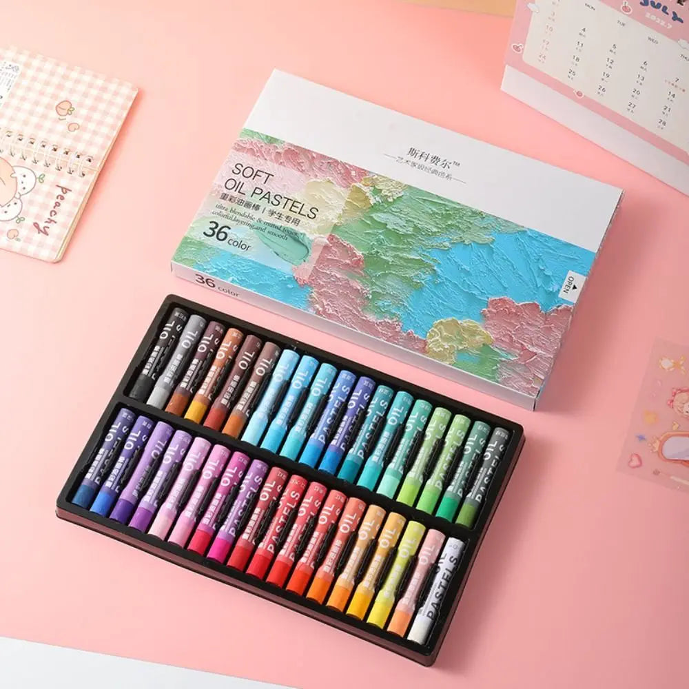 A set of 36 soft oil pastels in various colors is displayed on a pink surface next to its packaging.