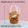 A flat hot air balloon bear cake topper in brown and yellow colors