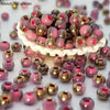 A pile of vibrant pink and gold round beads for jewelry making