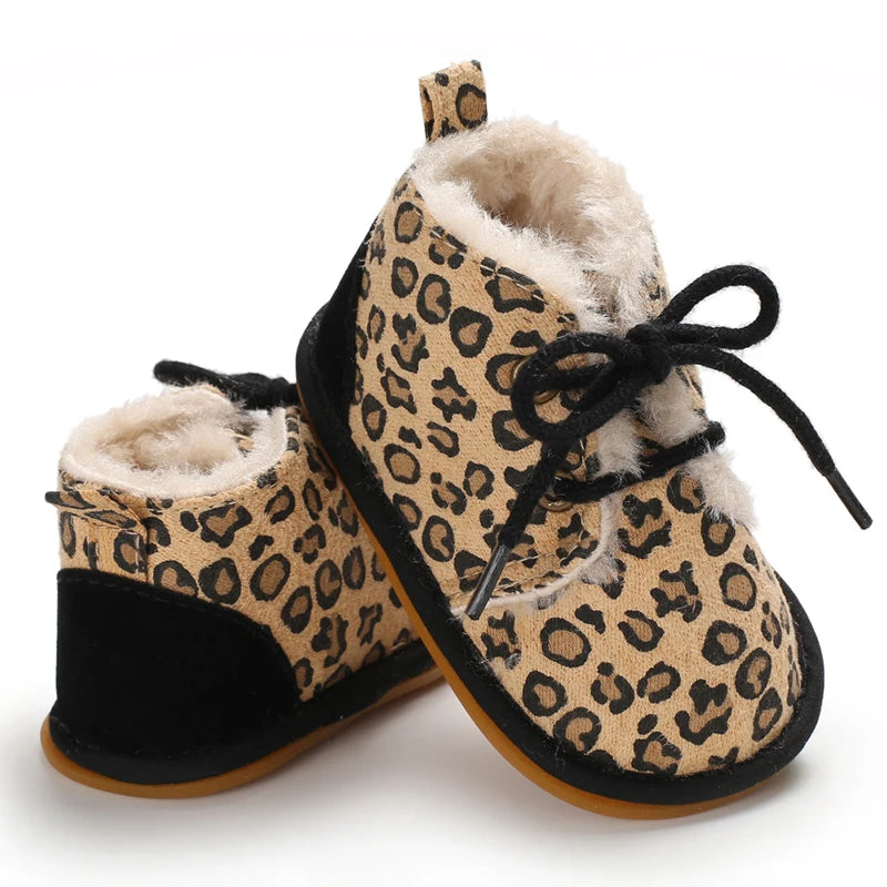 A pair of leopard print soft sole baby sneakers with black laces and fuzzy lining.