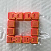 A bracelet made of orange fidget cubes with interlocking plastic links.