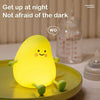 A yellow pear-shaped color-changing night light sits on a green plate.