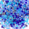 A pile of faceted crystal bicone glass beads in various shades of blue and purple for jewelry making