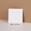A white square jewelry display card with two small holes is shown against a beige background.