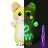 A split image of a yellow and green plush doll, showing a white section on the left and a glowing green section on the right.