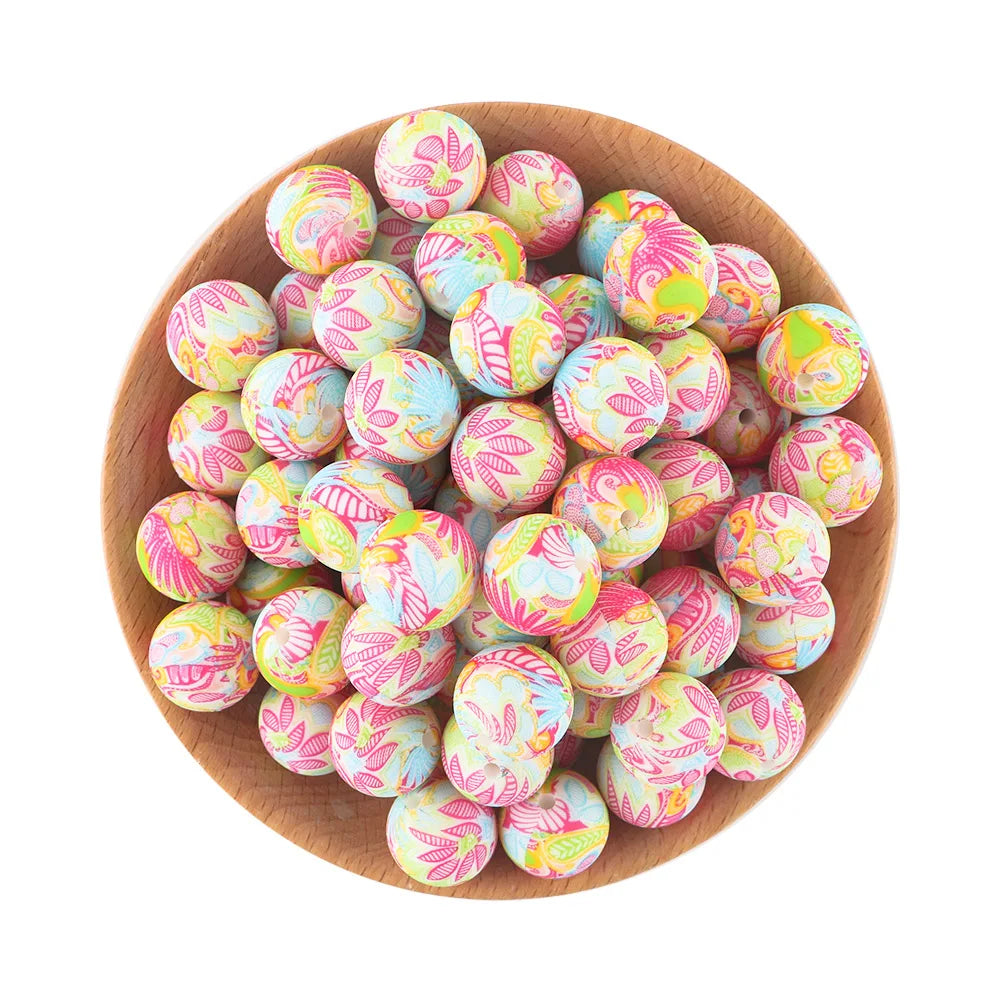 A bowl filled with pink and blue patterned silicone beads for jewelry making