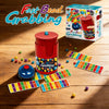 A box and several game boards of the Fast Bead Grabbing board game with a bell for two players on a wooden surface.