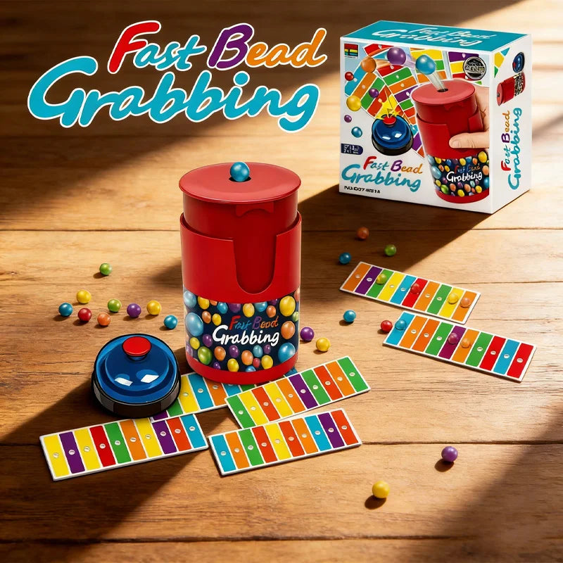 A box and several game boards of the Fast Bead Grabbing board game with a bell for two players on a wooden surface.