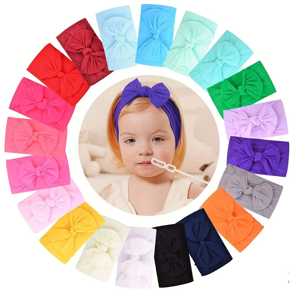 A collection of colorful nylon knit bow headbands for baby girls arranged in a circular pattern.