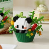 A building block set depicting a panda face surrounded by green leaves and colorful flowers in a green pot.