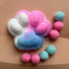A squishy fidget toy shaped like a cat paw made of soft, pastel pink and blue mochi-like material.
