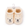 Pair of handmade knitted baby booties shaped like bears with non-slip soles
