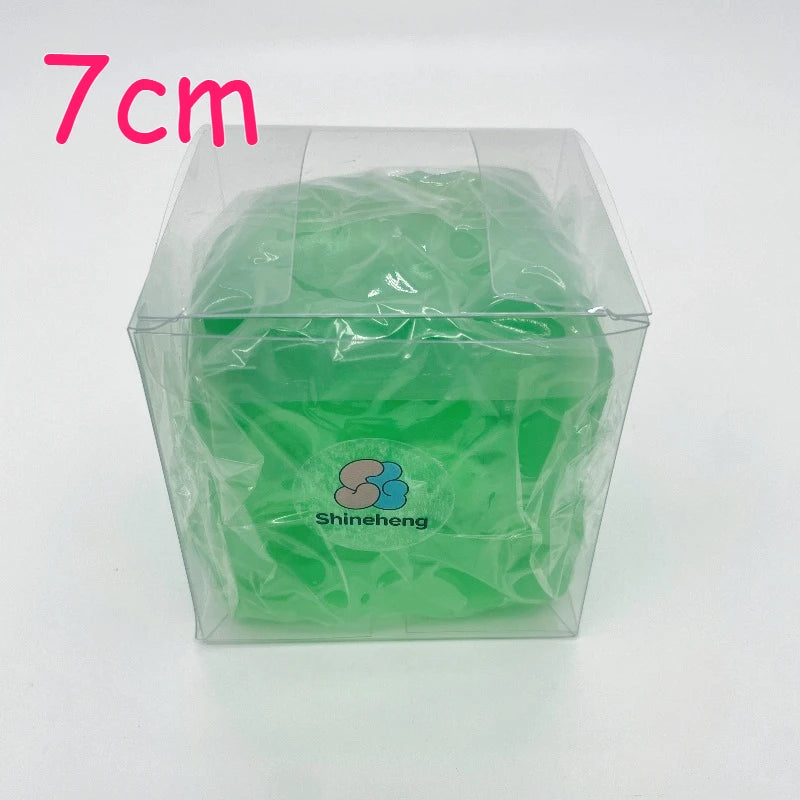 A clear plastic container holds a green, squishy stress ball scented with coconut oil.