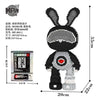 A black embroidered bunny figure made of micro building blocks with a measuring scale.