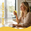A woman is relaxing and smiling while holding a yellow squishy toy on a wooden table.