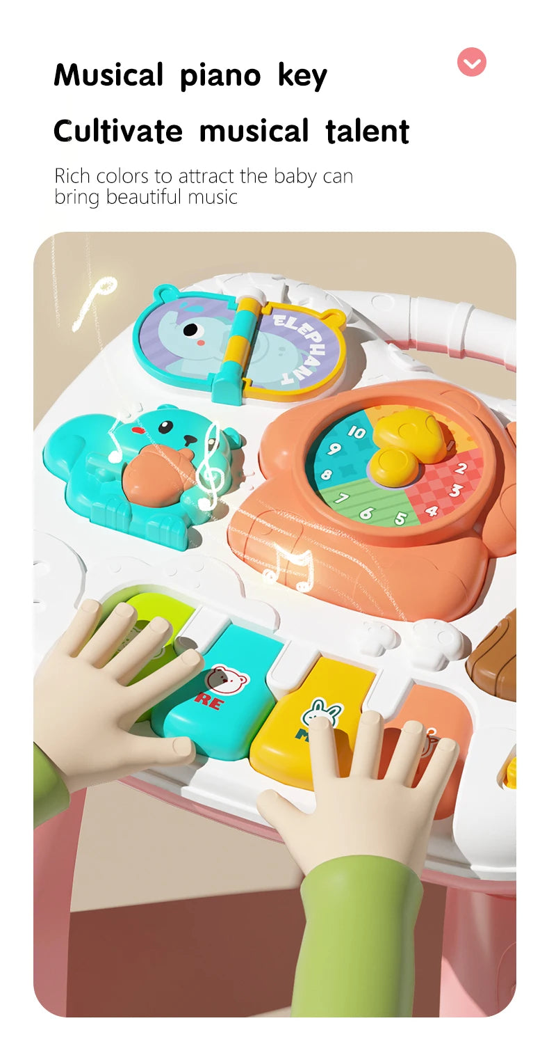 A hand plays a musical piano key on a colorful playmat featuring light-up buttons and hanging toys for babies.