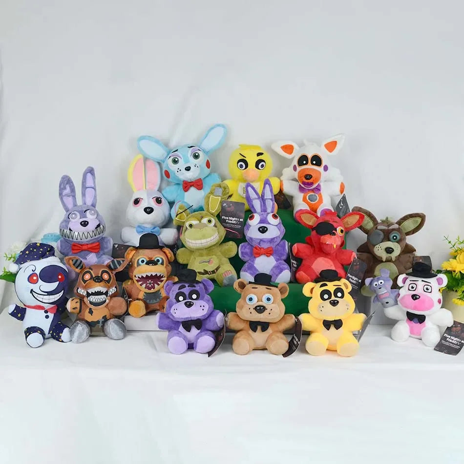 A collection of Five Nights at Freddy's plush toys including Bonnie, Foxy, Freddy, and other characters arranged on a white s