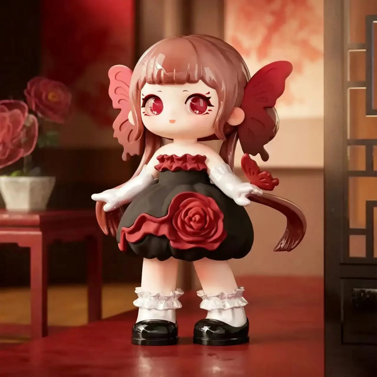 A collectible figurine of a girl with pink hair and red eyes, featuring rose and butterfly elements on her outfit.
