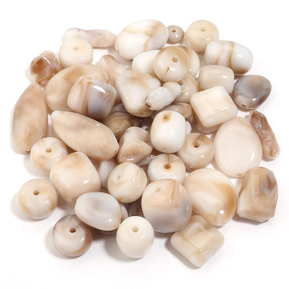 A pile of colorful, translucent acrylic beads in various shapes and sizes for jewelry making